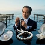 A man in a tuxedo examining a pearl necklace surrounded by open oysters in water.