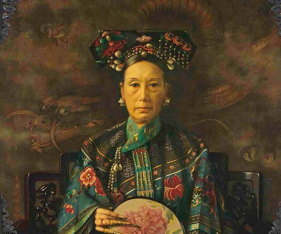 Portrait of Empress Dowager Cixi wearing traditional attire and holding a fan with a floral design.