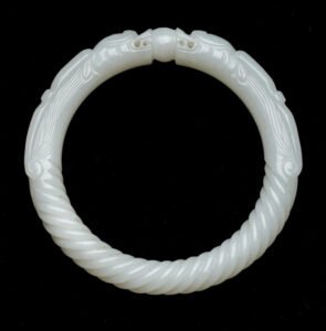 White bracelet featuring two dragon figures and a central pearl design.