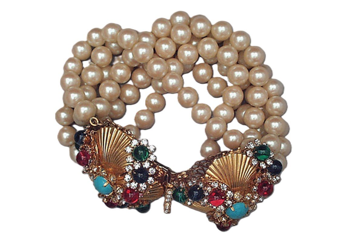 A pearl bracelet featuring a decorative clasp with colorful stones and shell design.