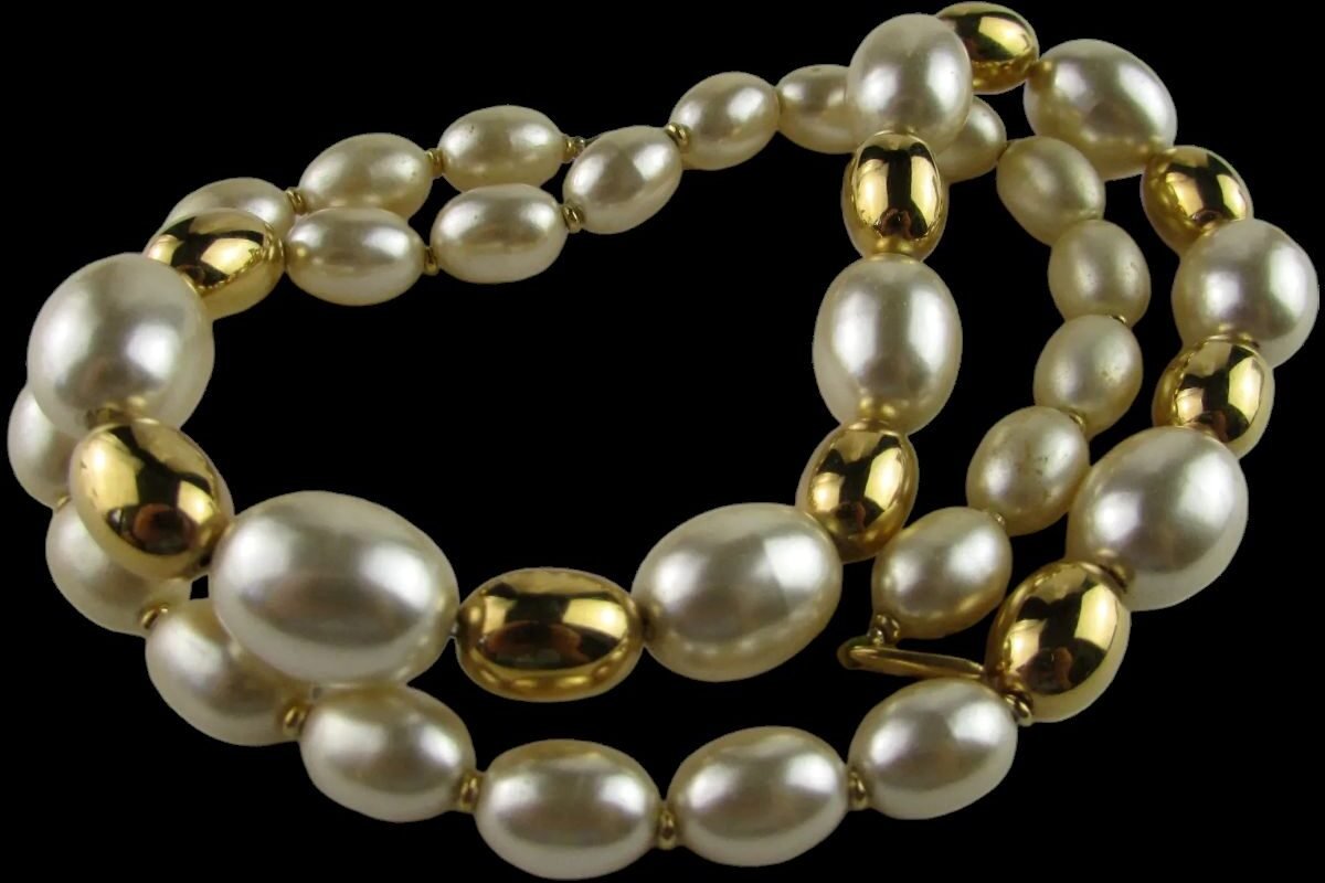 Faux pearl necklace with gold-tone beads, featuring a mix of oval and round shapes in a classic design.