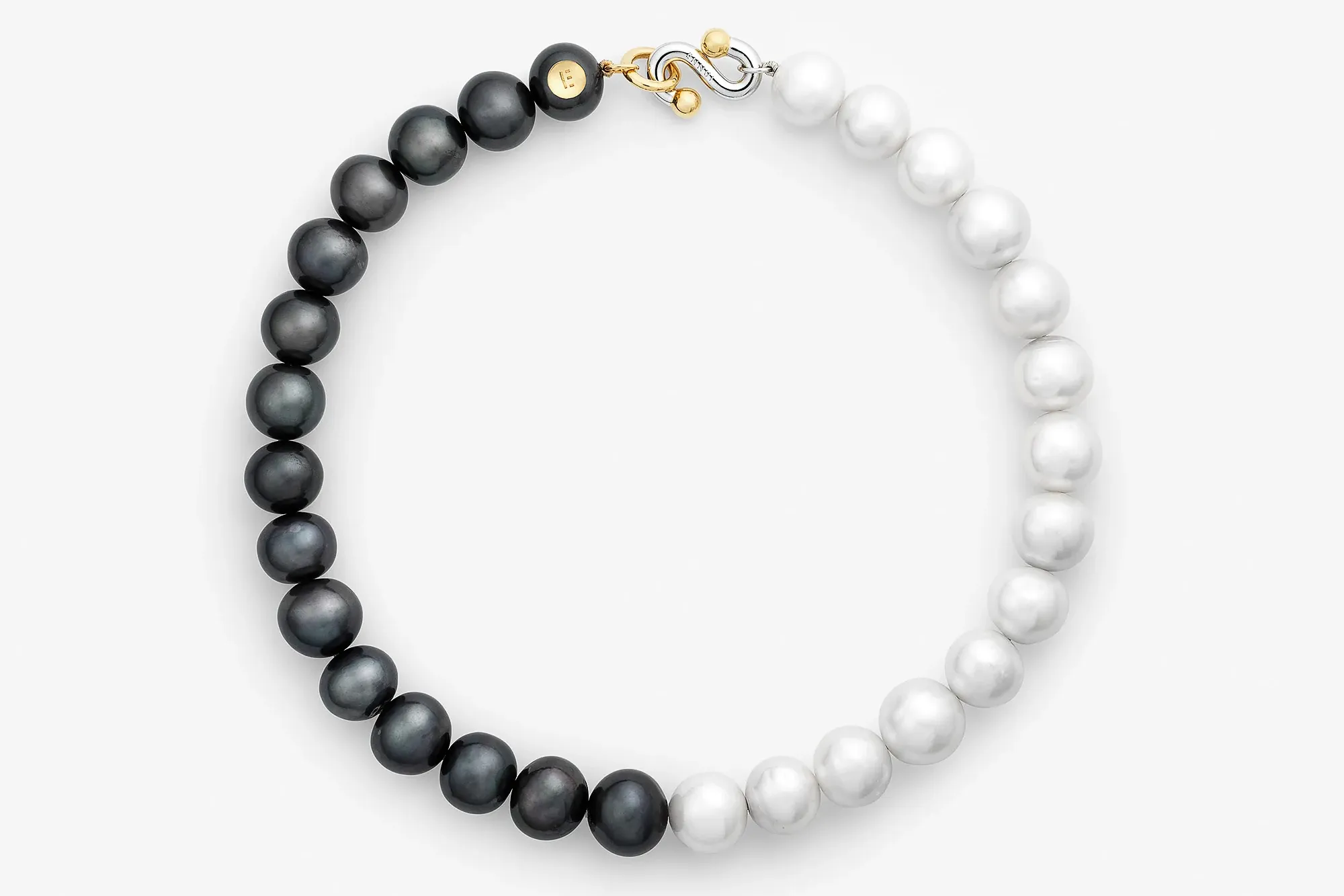 Black and white pearl necklace featuring alternating black and white pearls with a gold clasp.