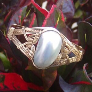 Osmena pearl bracelet with a large, irregularly shaped silver-blue pearl set in a woven gold band.