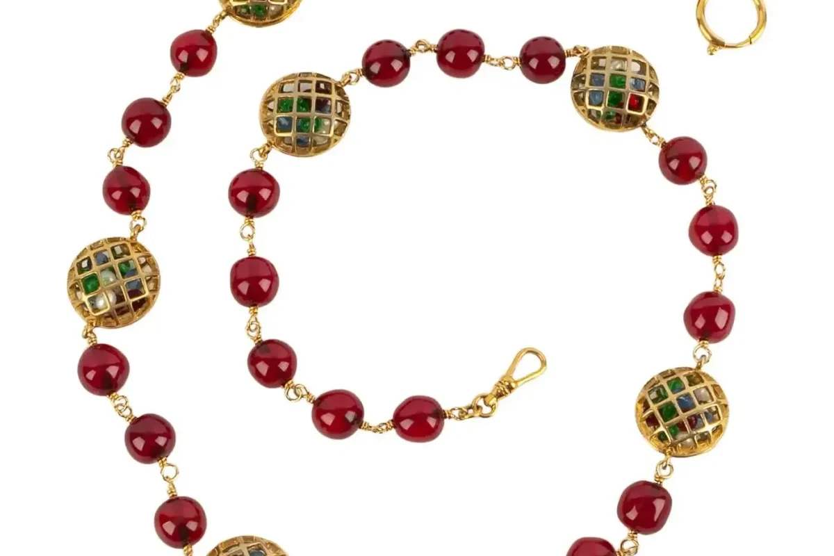 Chanel necklace from the 1990s featuring red beads and gold accents with decorative elements.