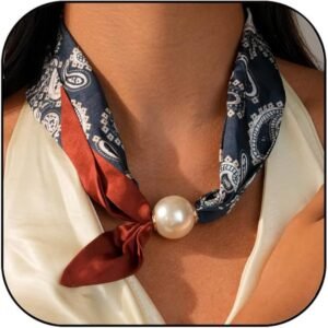 Scarf necklace with a large pearl charm and a patterned fabric in navy and burgundy colors worn around the neck.
