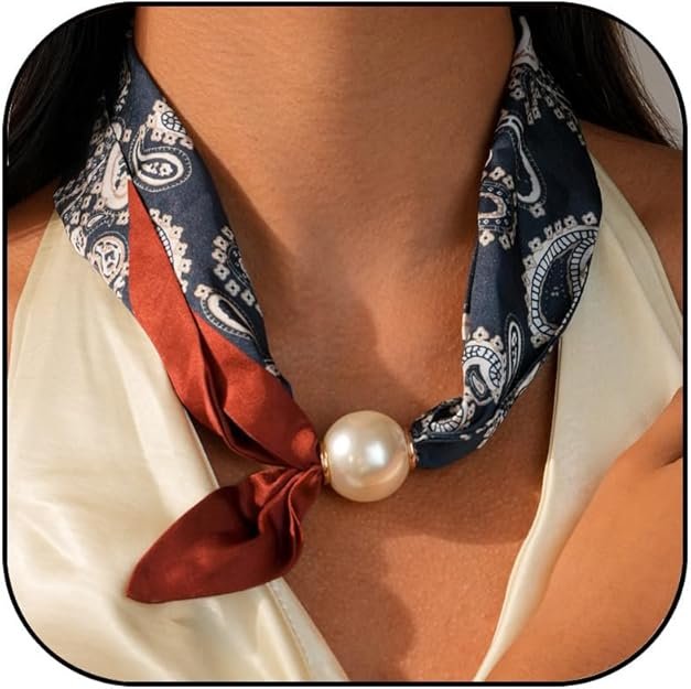 Scarf necklace with a large pearl charm and a patterned fabric in navy and burgundy colors worn around the neck.