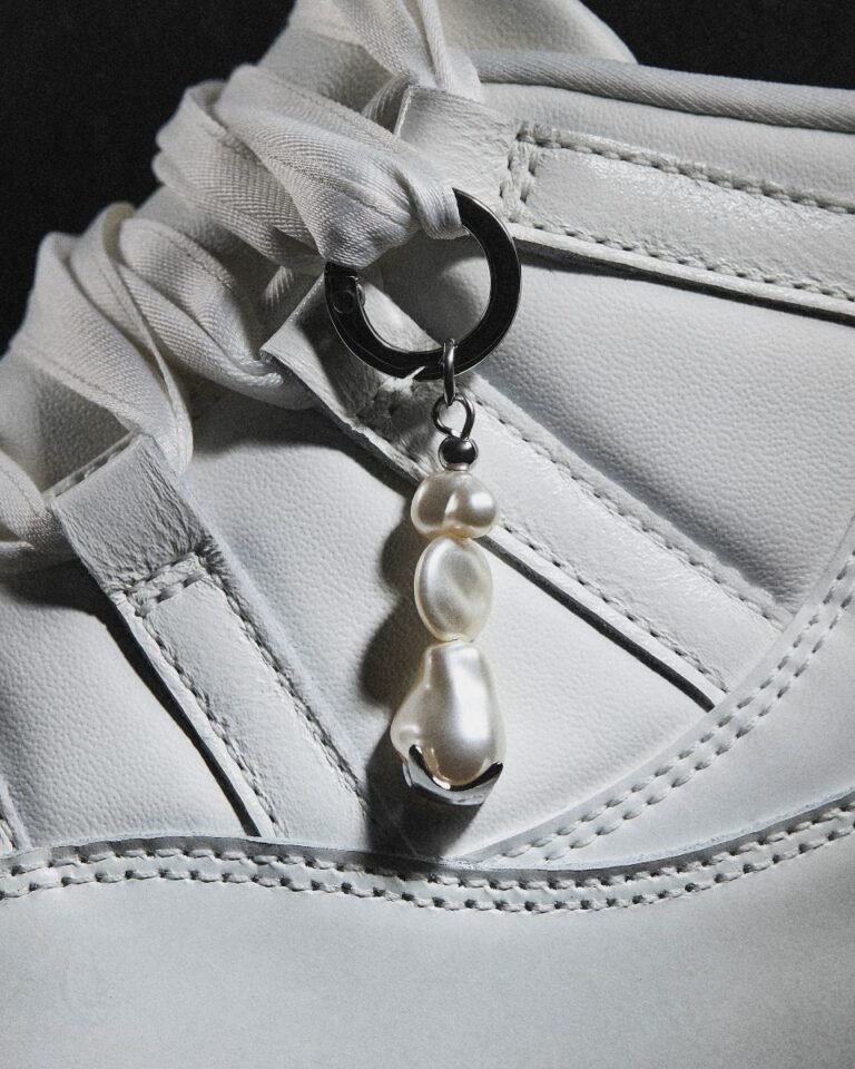 Pearl-inspired Air Jordan 11 keychain on a pearl-white sneaker lace, with a lustrous pearl charm and stitched detailing in soft silver tones.